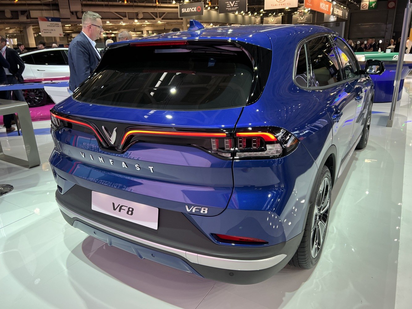 Rear view of blue electric SUV with distinctive LED taillights and VinFast branding.