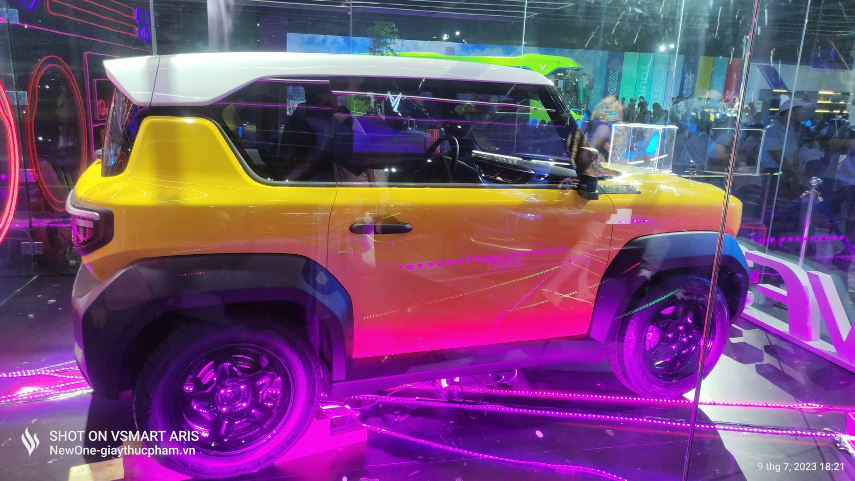 Compact electric vehicle in yellow and white with rugged black accents