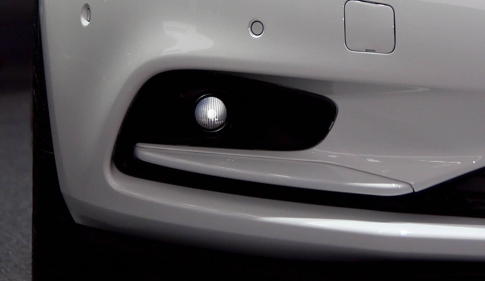 Front fog light and bumper section with sleek trim.