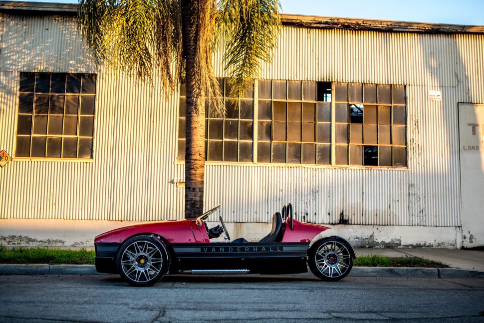 Open-top three-wheeler with sporty wheels in side profile.