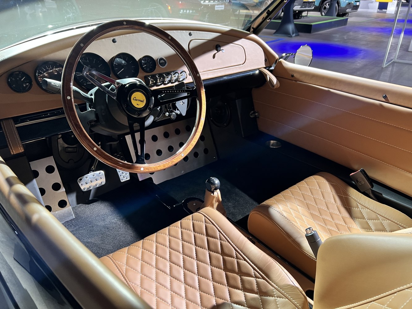 Tan quilted leather seats and wood-trimmed steering wheel with classic gauges