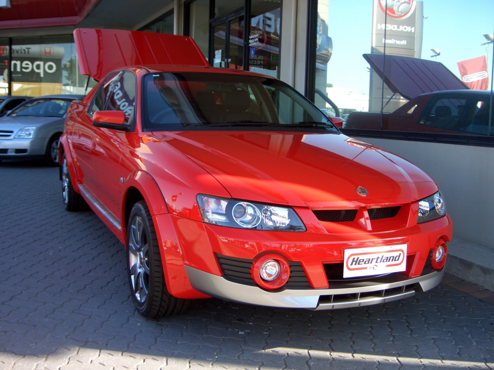 Red pickup with aggressive front headlights and round fog lights