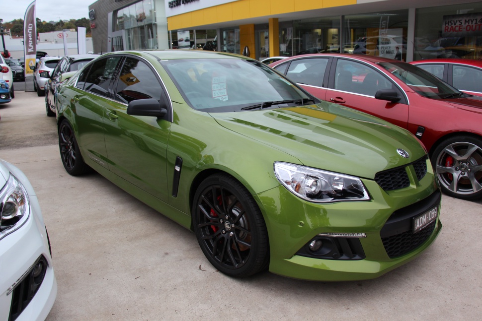 Green sedan with black alloy wheels and aggressive front grille