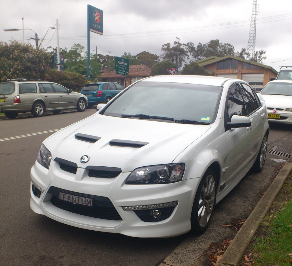 White performance sedan with hood vents and aggressive front bumper