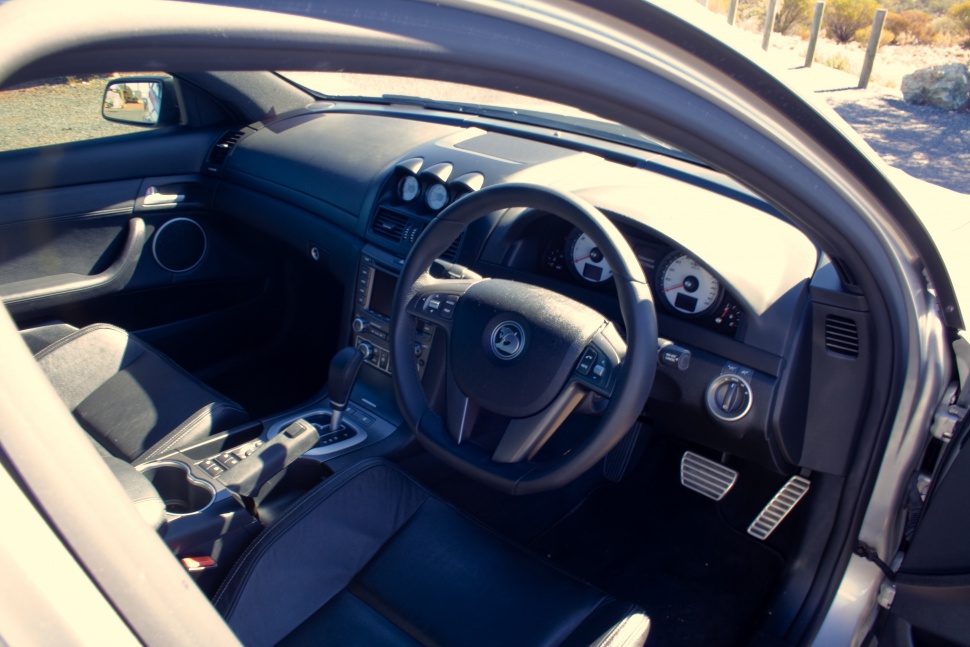 Sports car interior with dashboard, steering wheel, and automatic gear shift