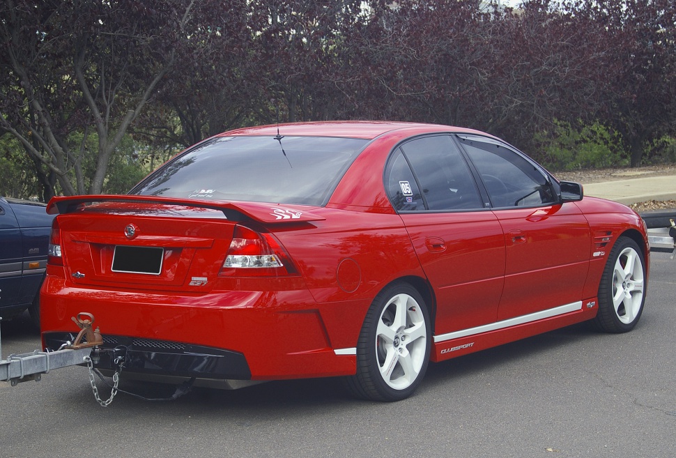 Red sedan with rear spoiler and white wheels