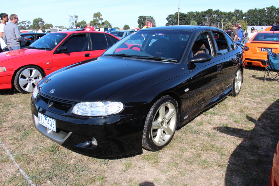 Black sedan with clear headlights and alloy wheels
