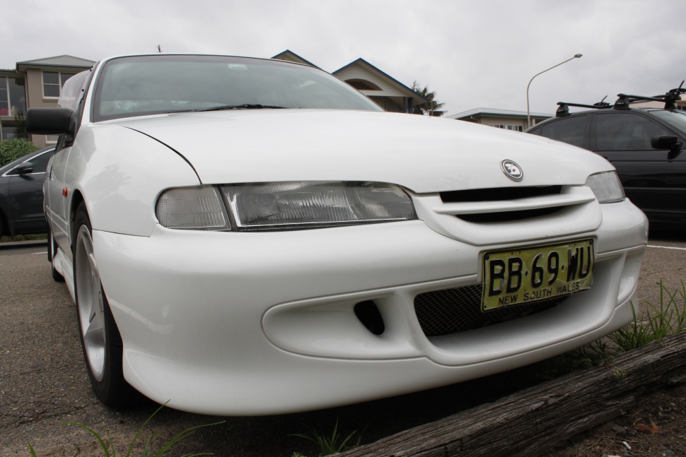 Close view of sleek headlights and front grille with integrated bumper.