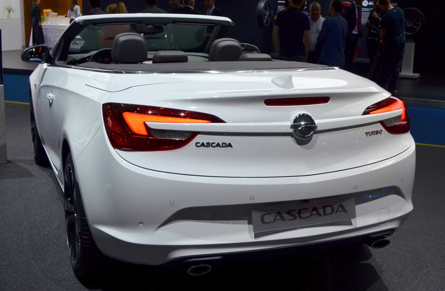 Rear view of white convertible with illuminated tail lights and turbo badge