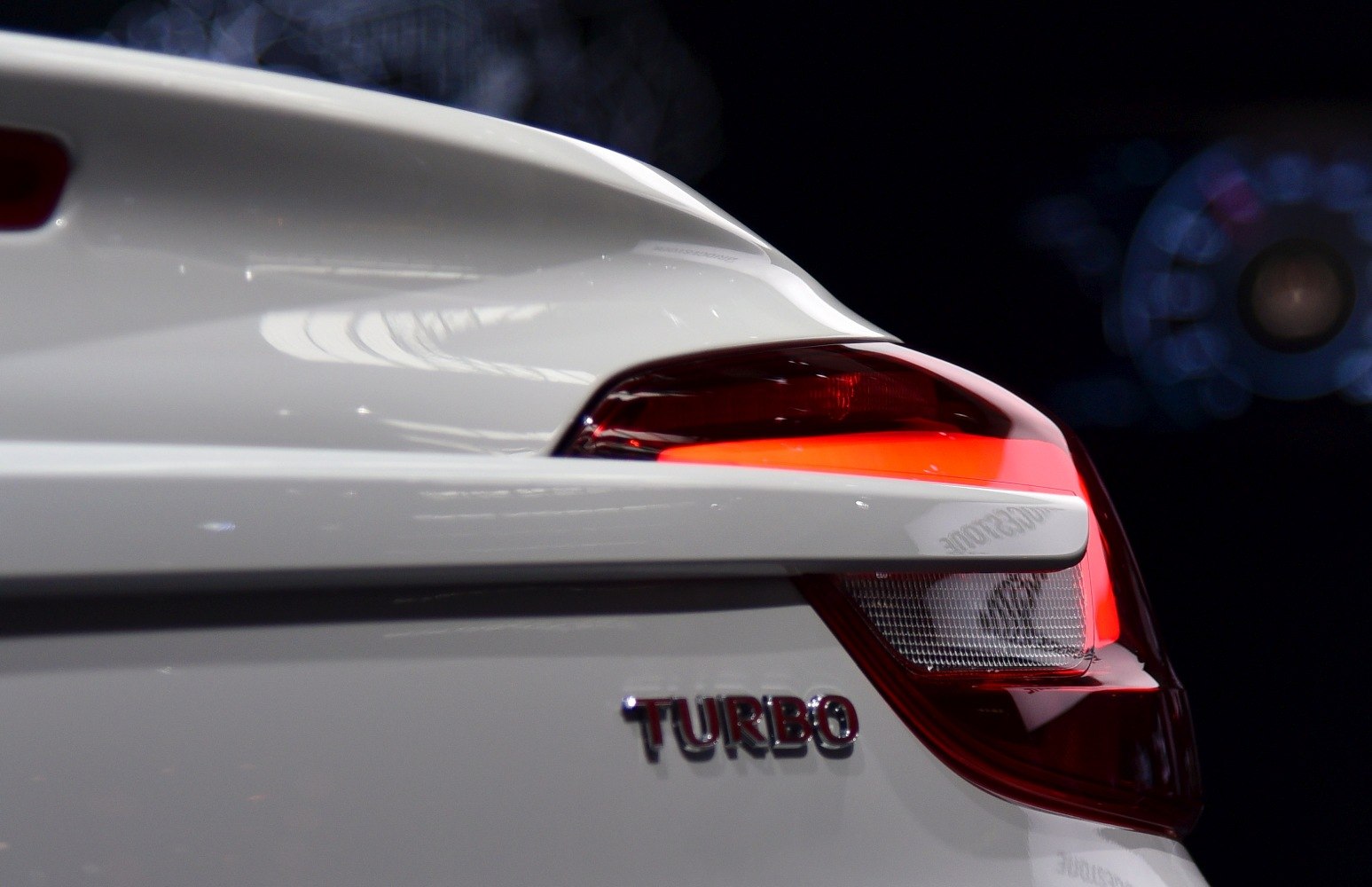 Close-up of rear light and turbo badge on white car