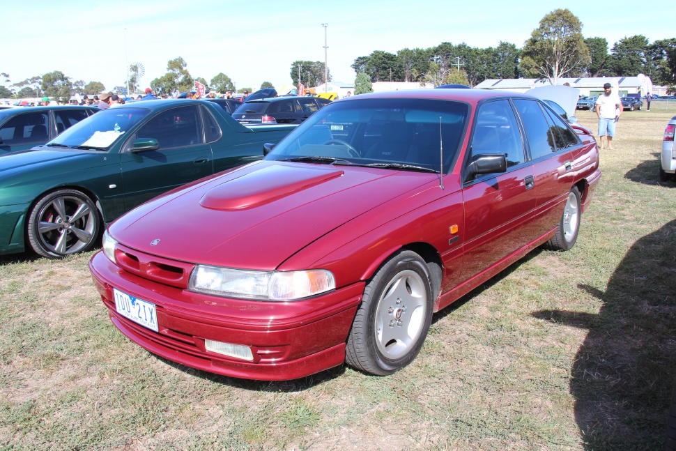 Red sedan with hood scoop and sporty wheels