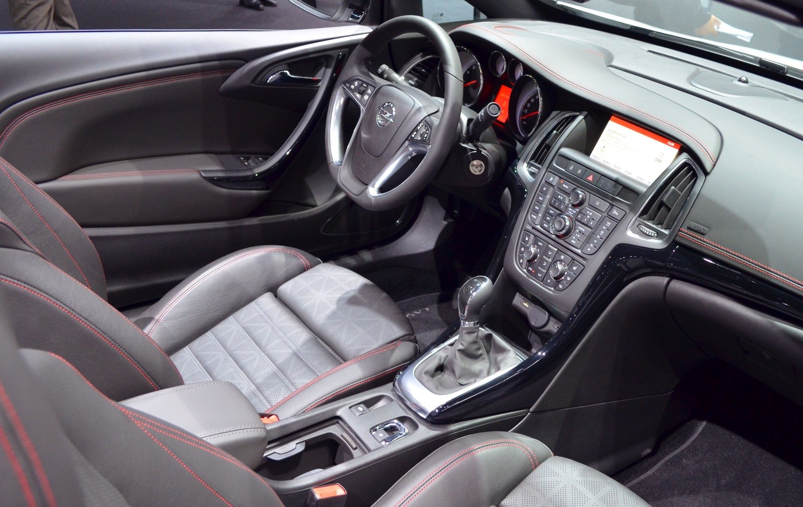 Steering wheel, dashboard, center console and front seats with red stitching.