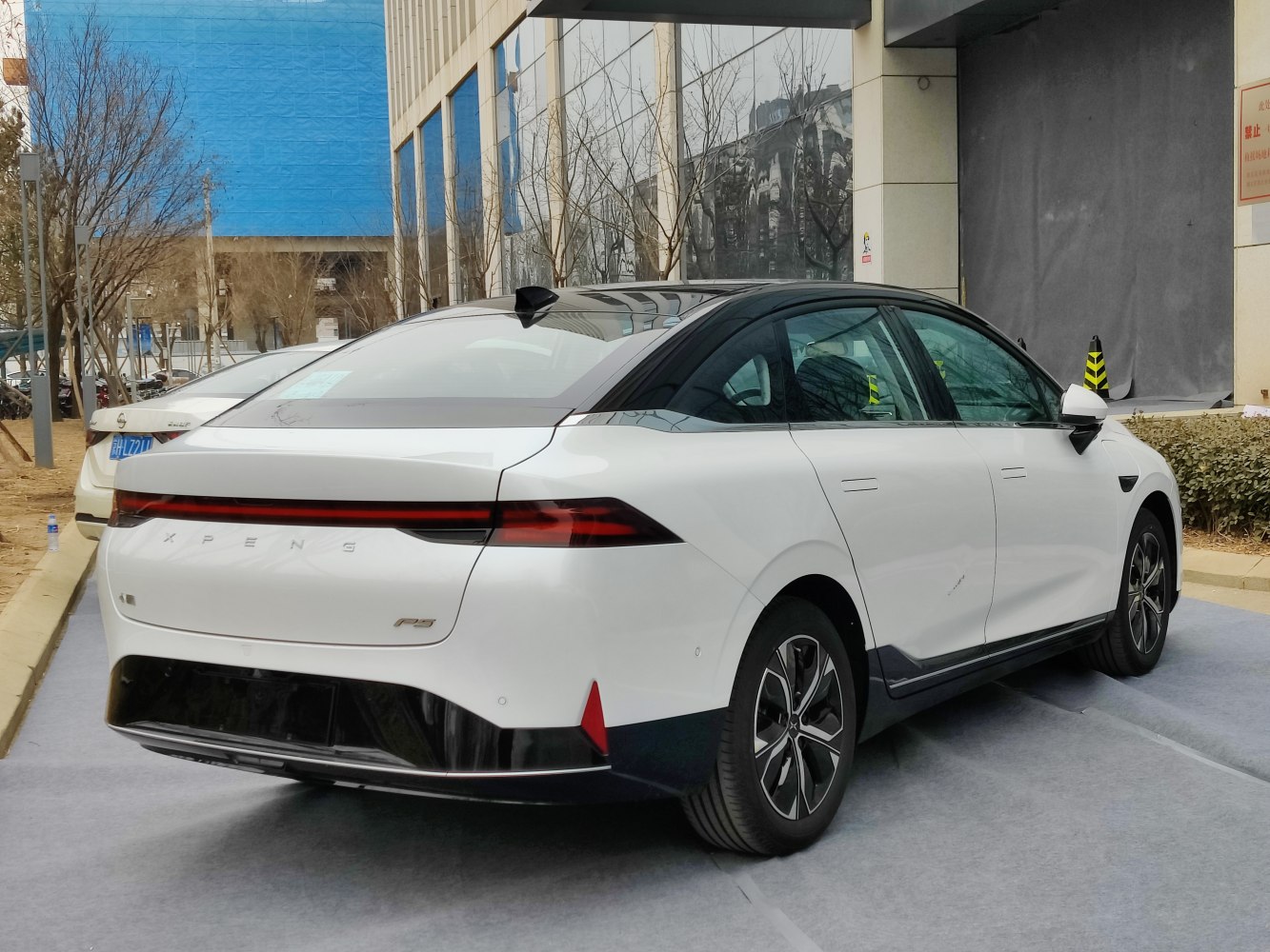 Rear view of electric sedan with continuous LED taillight and aerodynamic shape