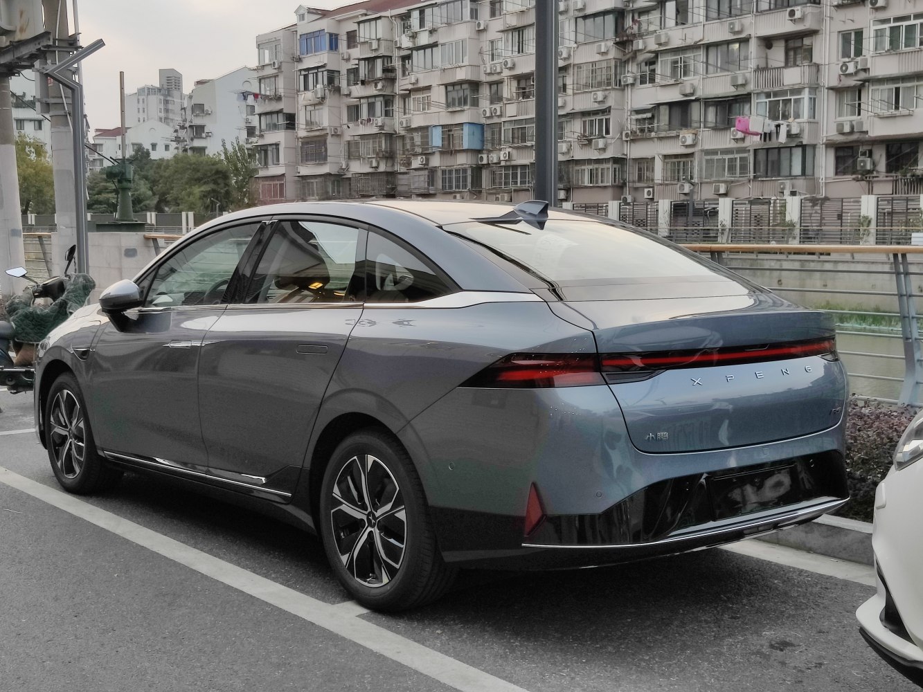 Rear and side view of modern electric sedan with sleek tail lights and alloy wheels