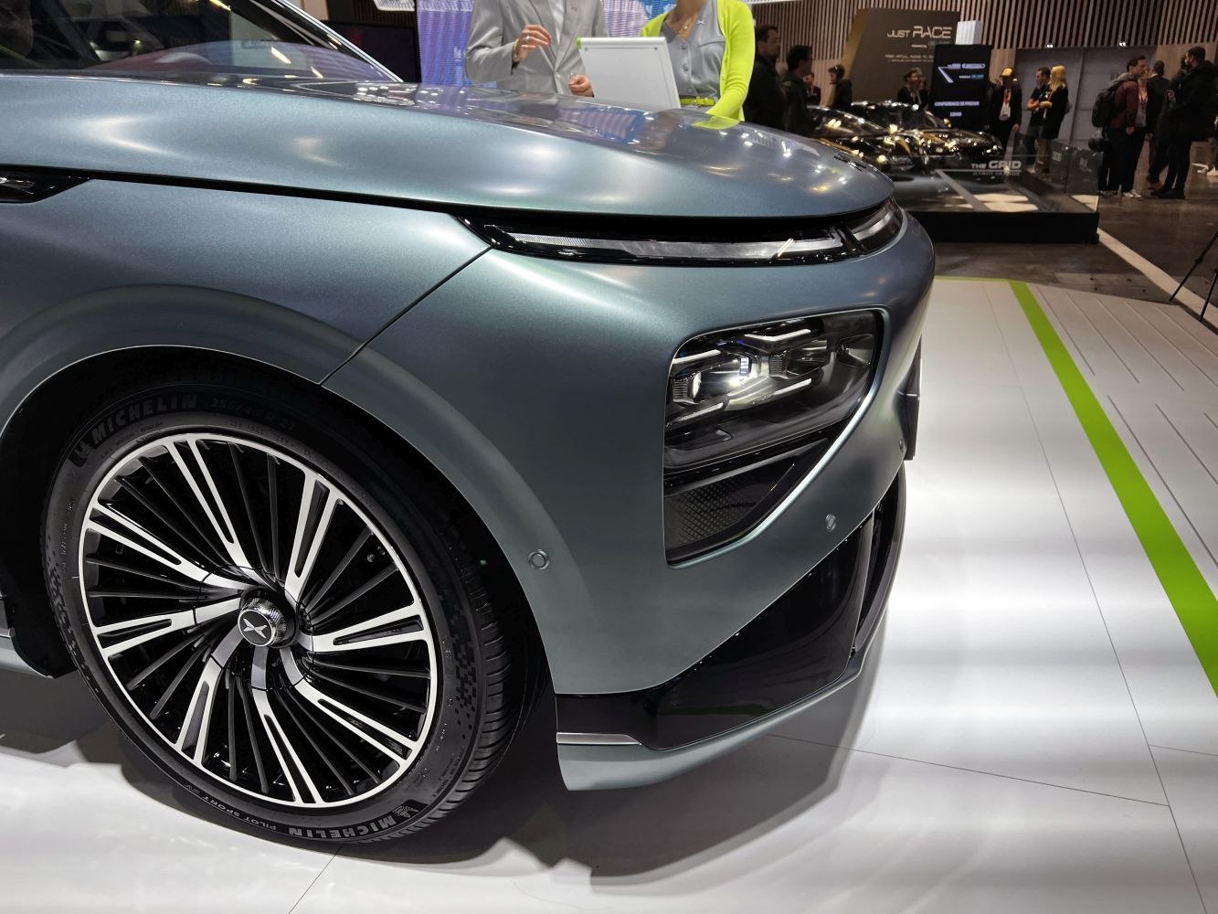 Close-up of front headlight and multi-spoke alloy wheel of modern electric SUV