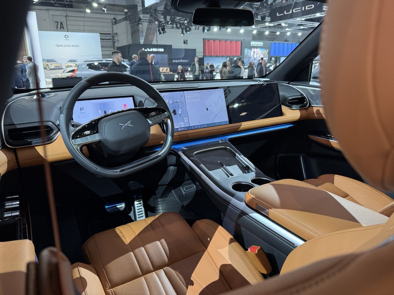 Dual wide digital displays with brown leather seats and modern steering wheel