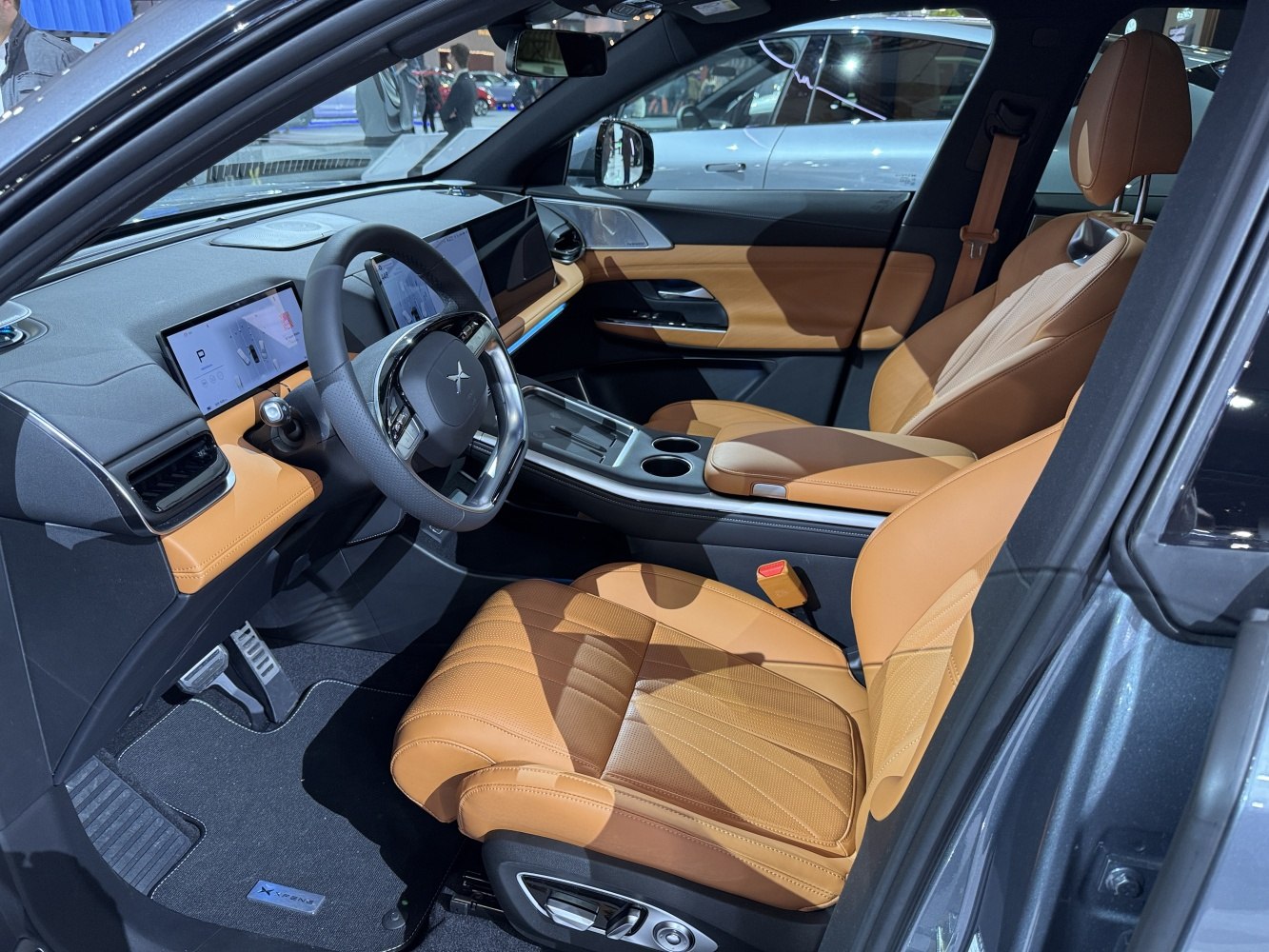 Tan leather seats and dual digital display screens in car interior