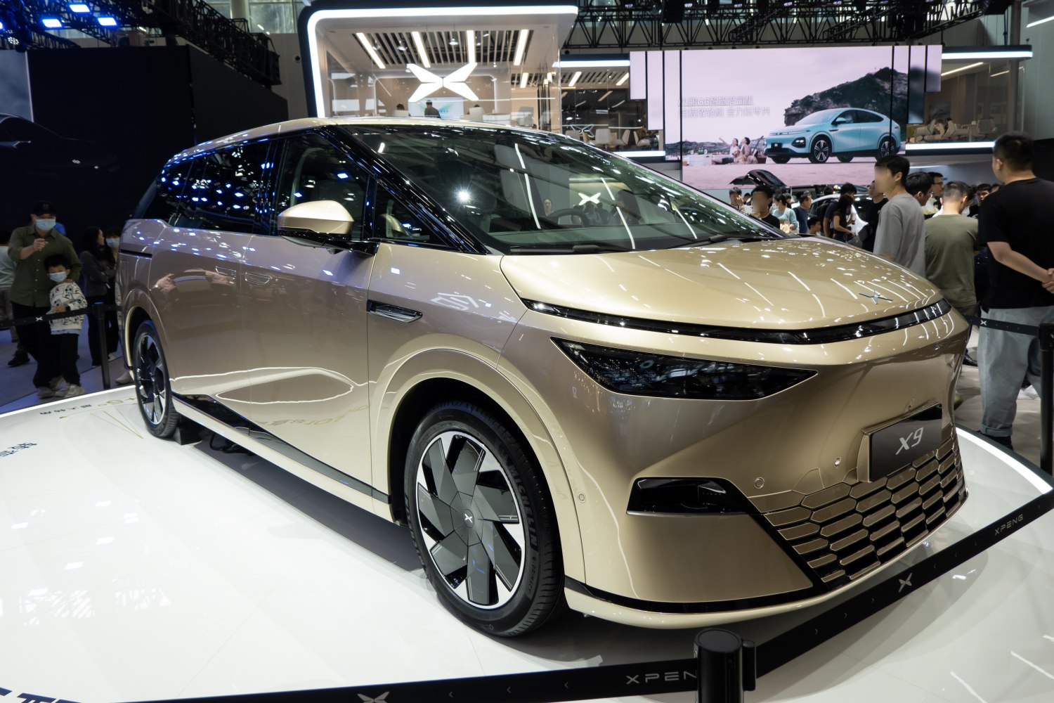 Sleek electric MPV with aerodynamic wheels and futuristic front design.