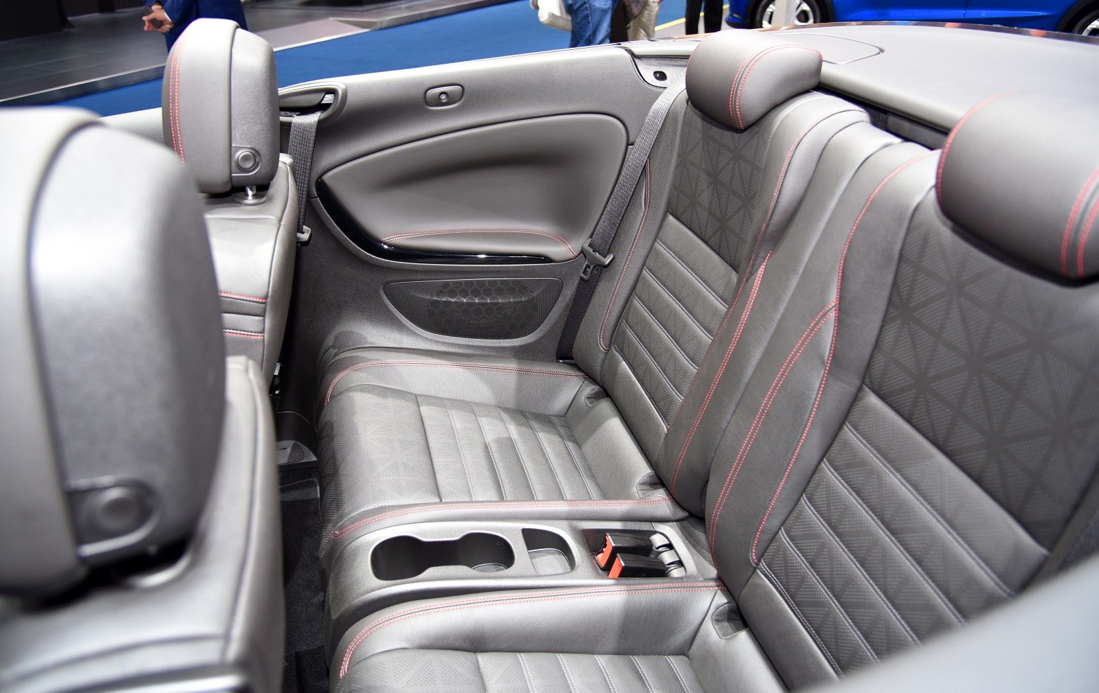Rear leather seats with red stitching and built-in cup holders