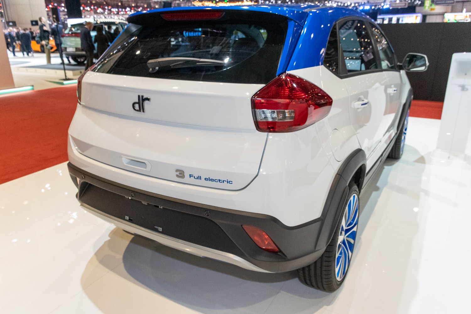 Rear view of a modern full electric compact SUV with blue-accented wheels