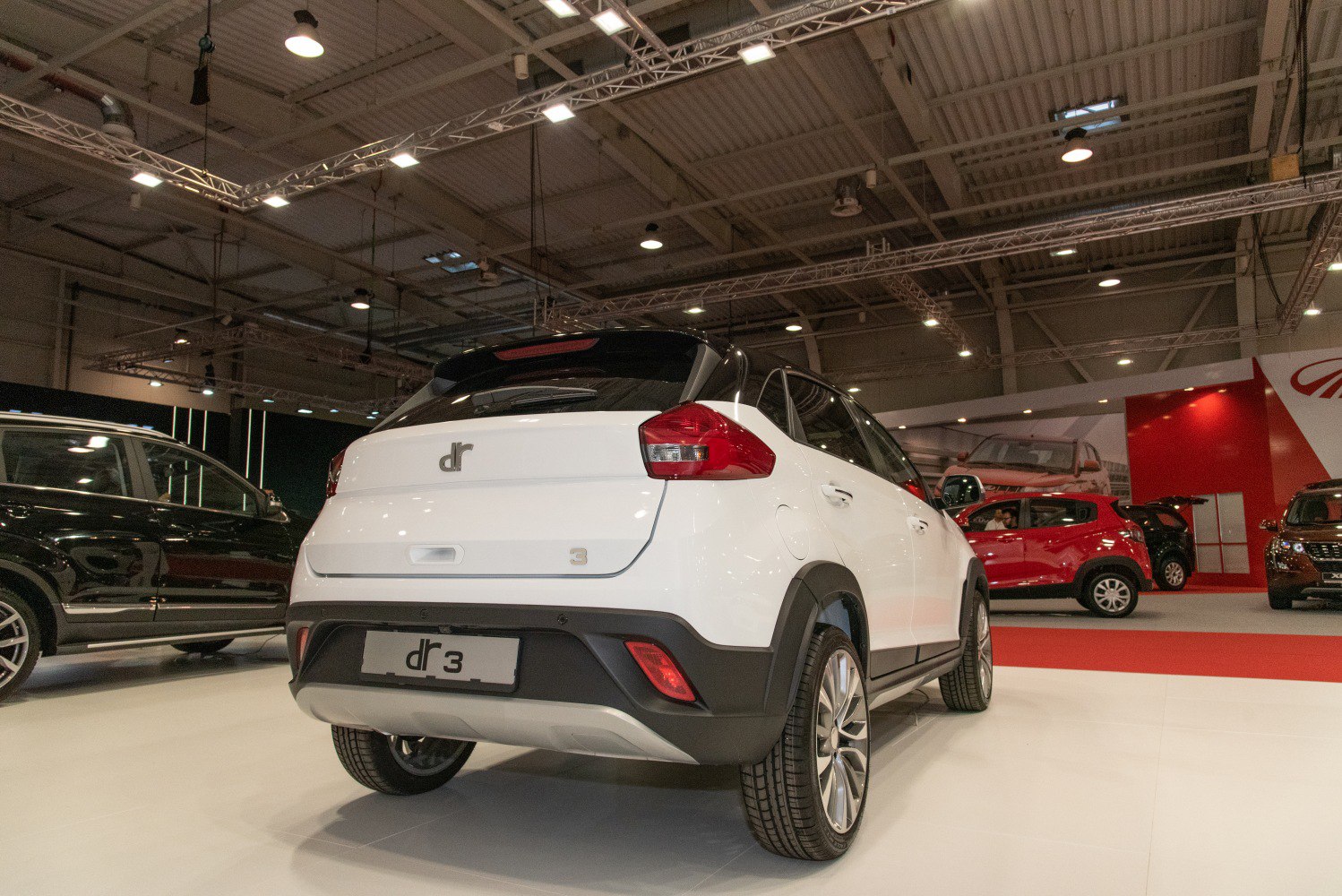 White SUV rear with black trim and modern tail lights in indoor exhibition