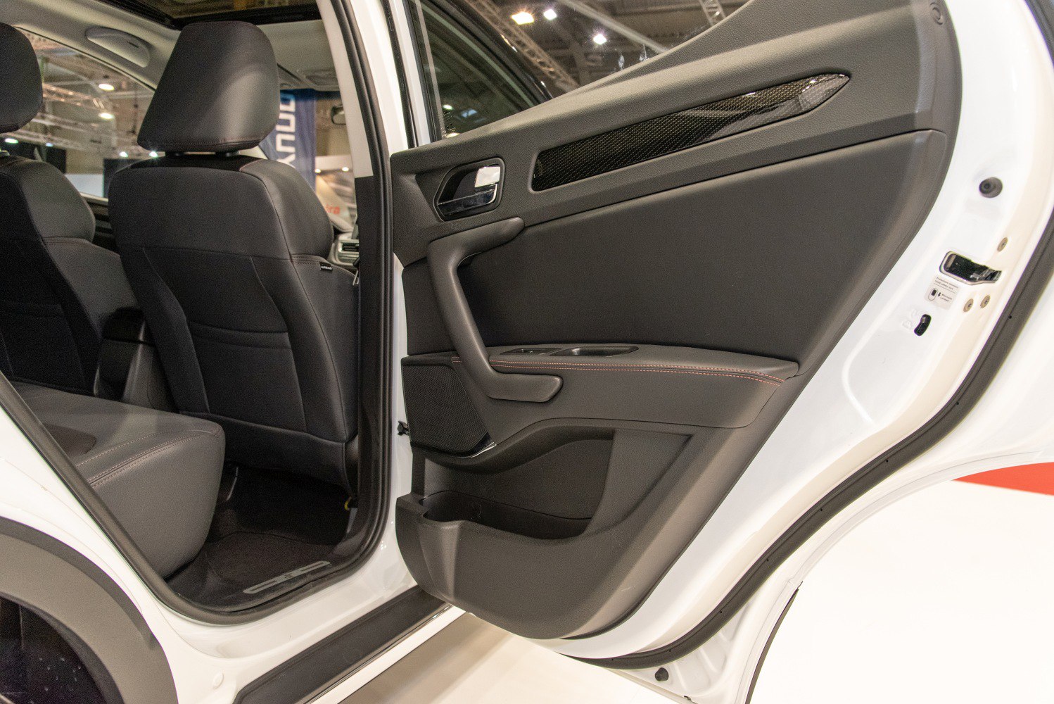 Rear door panel and black leather seating interior of a car.