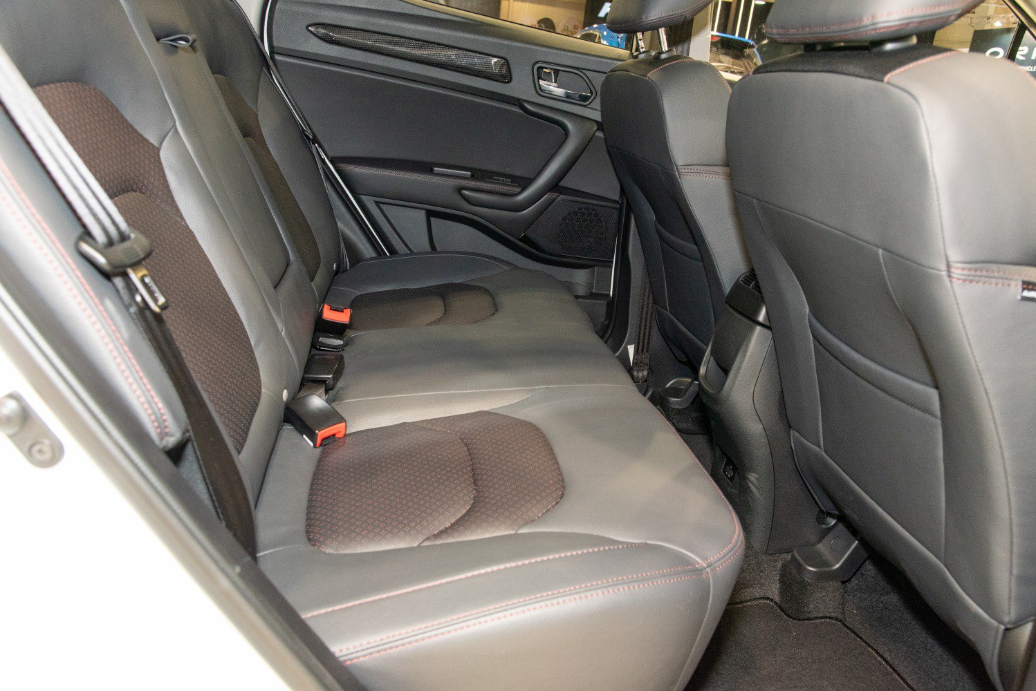 Rear passenger seat with black leather upholstery and detailed stitching