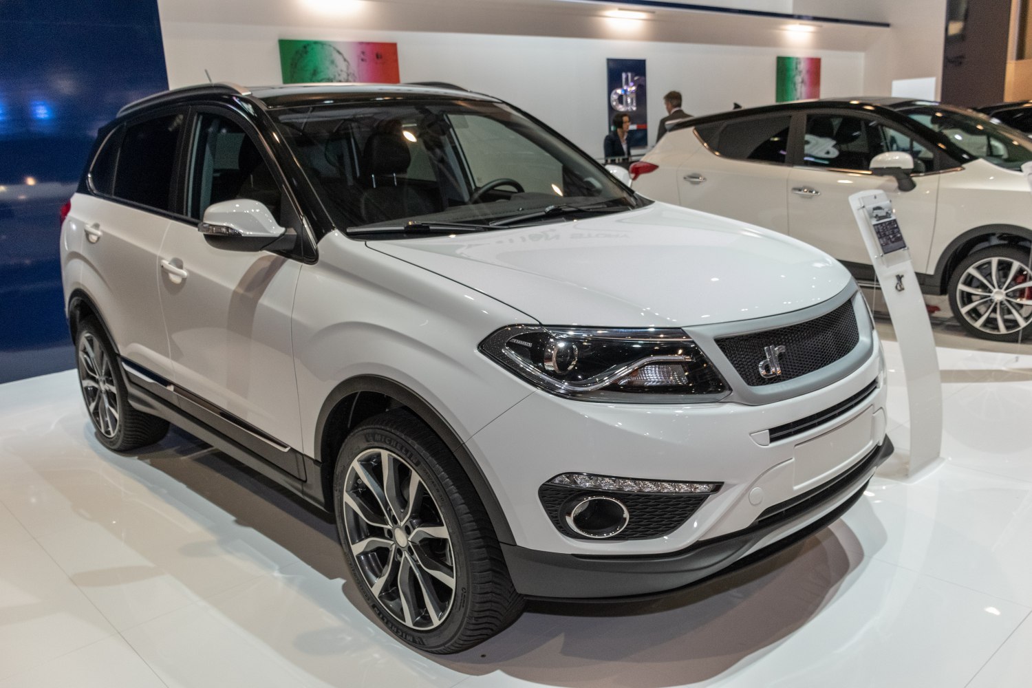 White SUV front and side view with headlights and alloy wheels