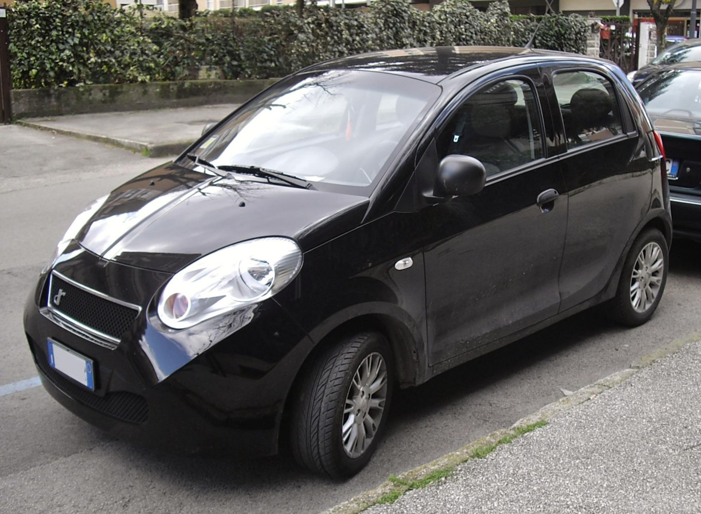 Compact hatchback with large rounded headlights and narrow grille