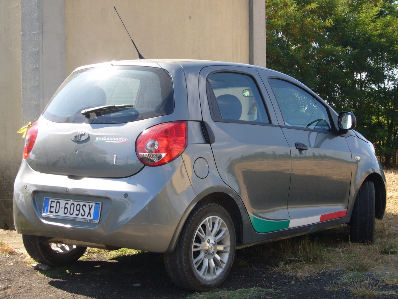 Rear-side view of compact hatchback with Italian flag decal