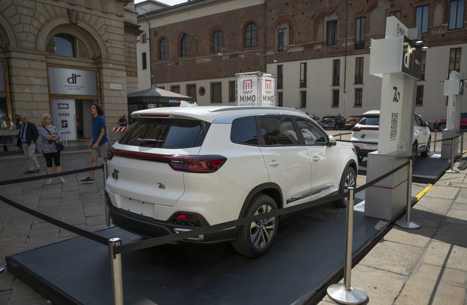 Rear view of a white SUV with modern LED taillights and roof spoiler
