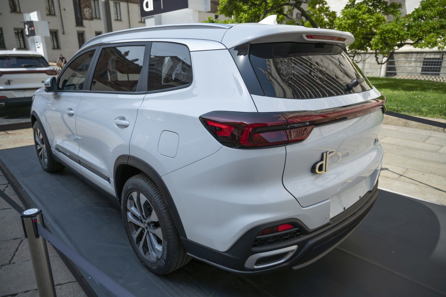 Rear and side view of white SUV with roof spoiler and modern tail lights