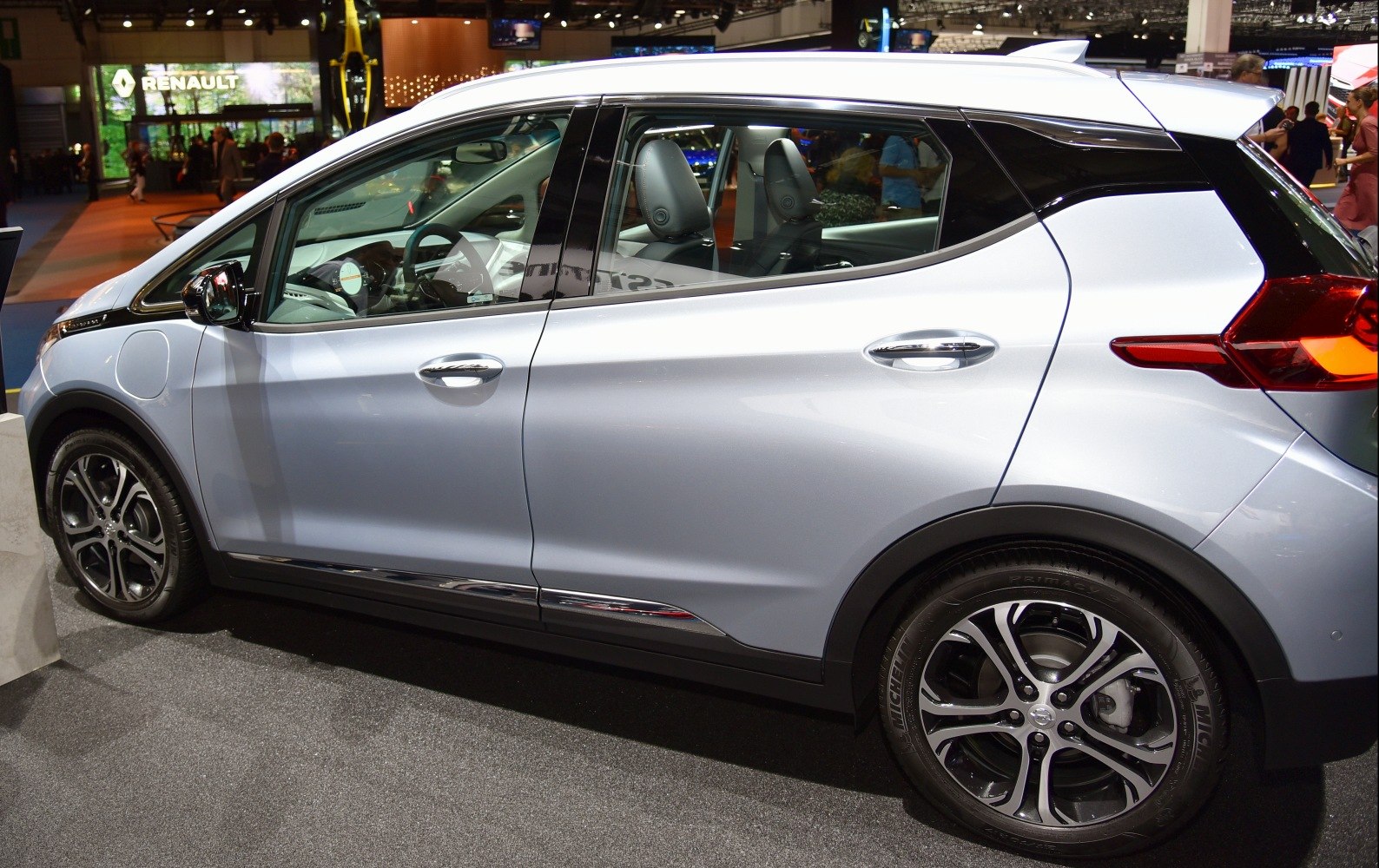 Side profile with alloy wheels and charging port of a modern electric hatchback