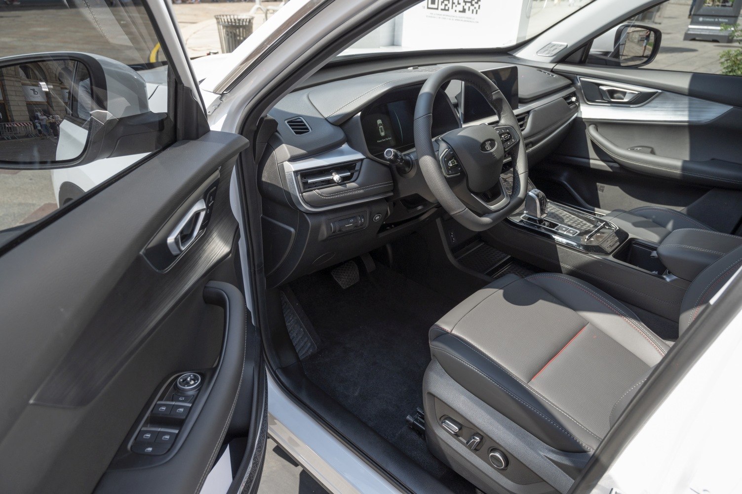 Modern car interior with dashboard, multifunction steering wheel, and ergonomic seat.