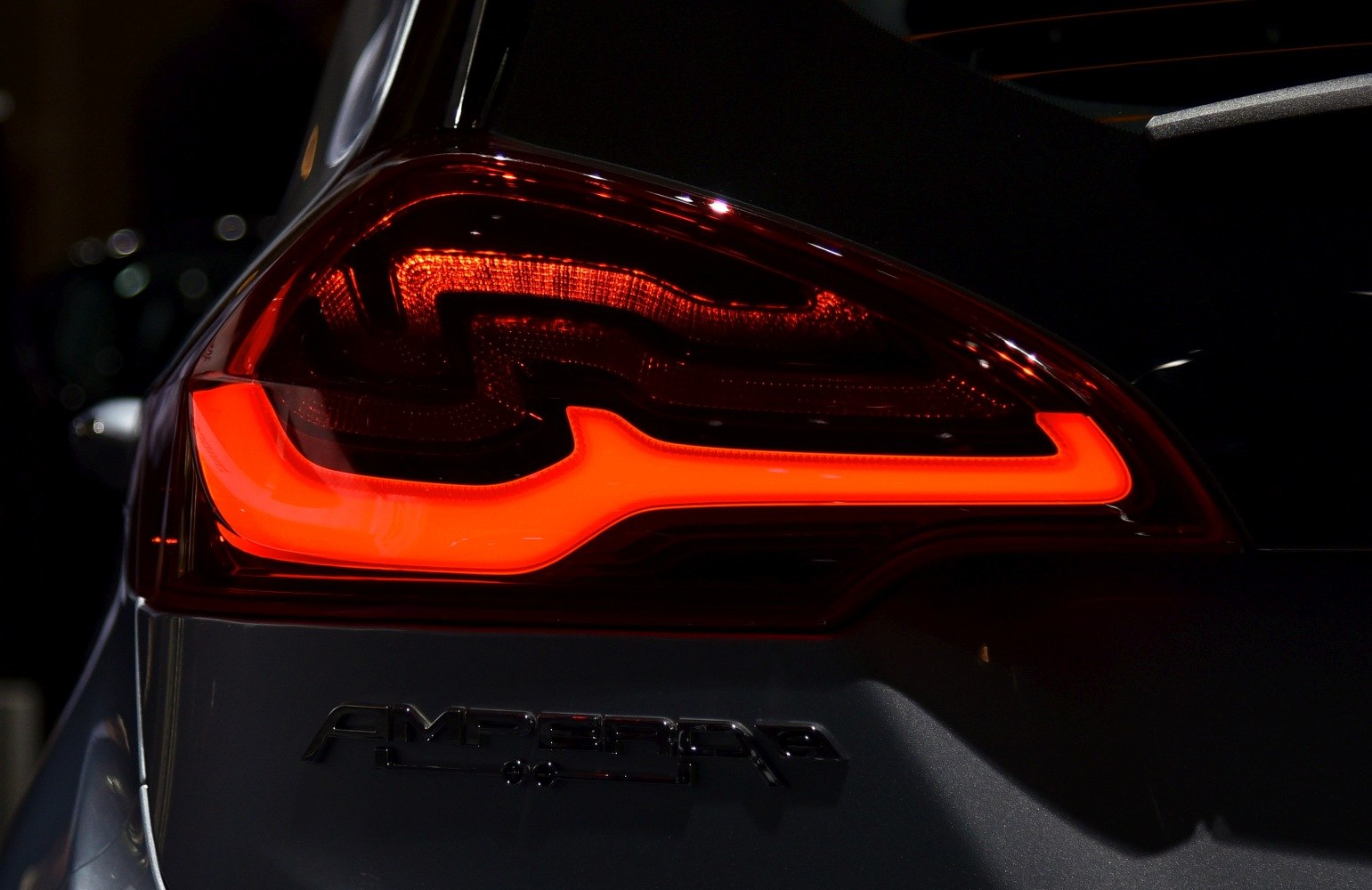 Close-up of glowing LED rear tail light and emblem