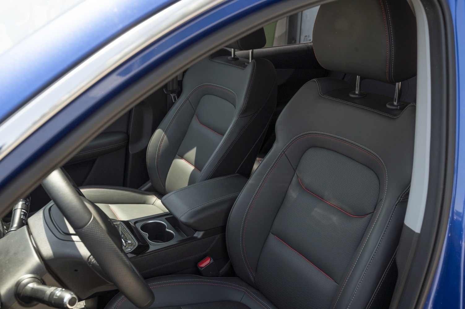 Premium leather front seats with red stitching and ergonomic design