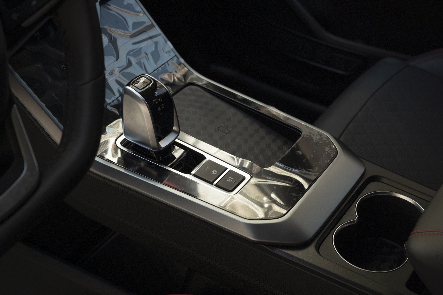 Gear shift lever and chrome-accented center console with electronic parking brake buttons
