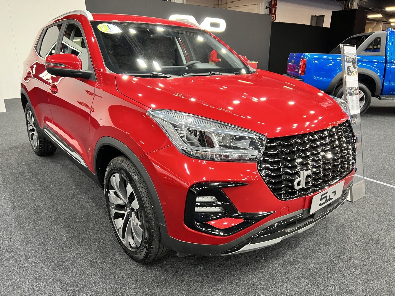Sleek LED headlights and sporty black grille on a red compact SUV.