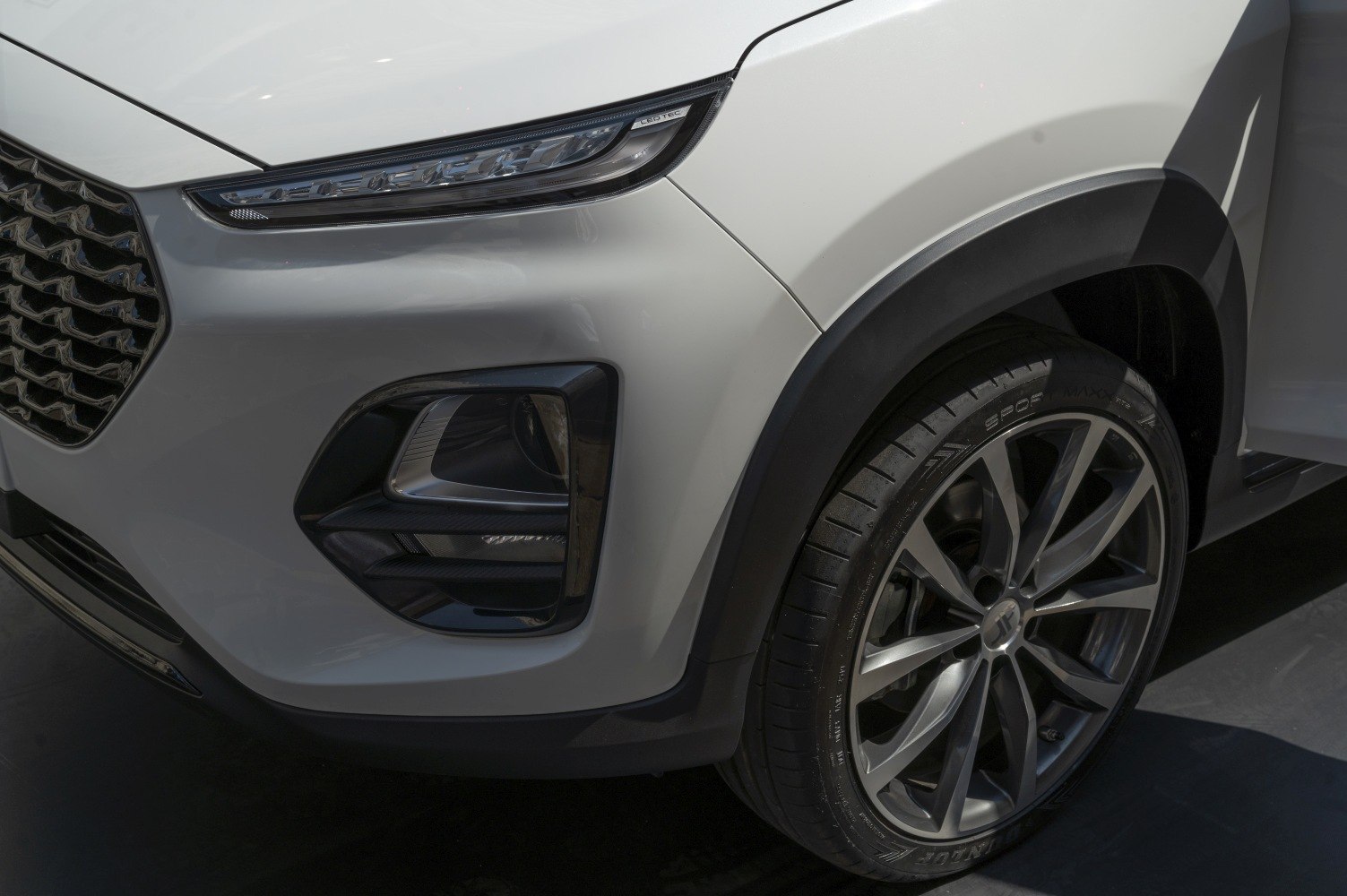 Close-up of front LED headlight, fog light, and alloy wheel with tire