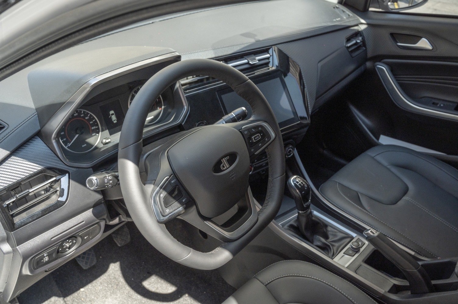 Car interior with multifunction steering wheel and manual gear shift