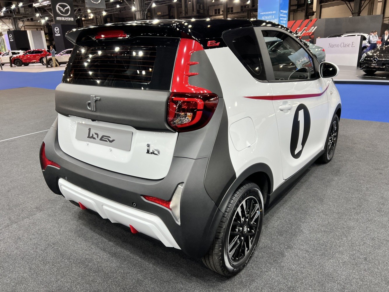 Rear-side view of compact electric hatchback with distinctive taillights and sporty black rims