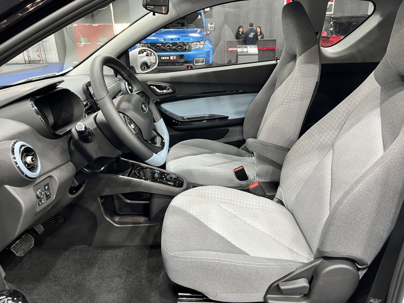 Modern electric car interior with digital dashboard and fabric seats