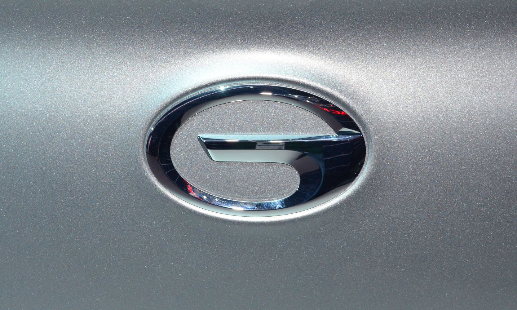 Close-up of a shiny chrome emblem on a metallic silver surface