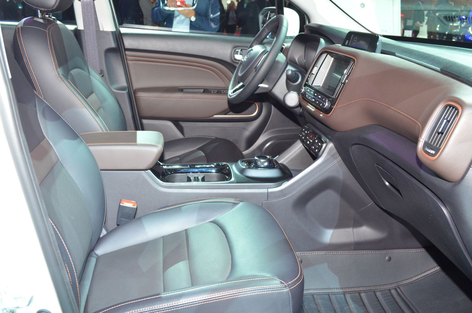 Car interior with dashboard, steering wheel, and leather seats with contrast stitching