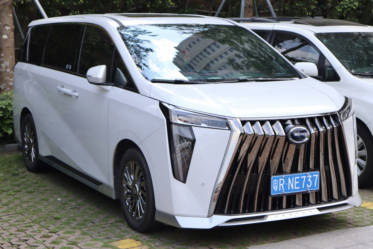 Minivan with large chrome vertical slat grille and angular LED headlights