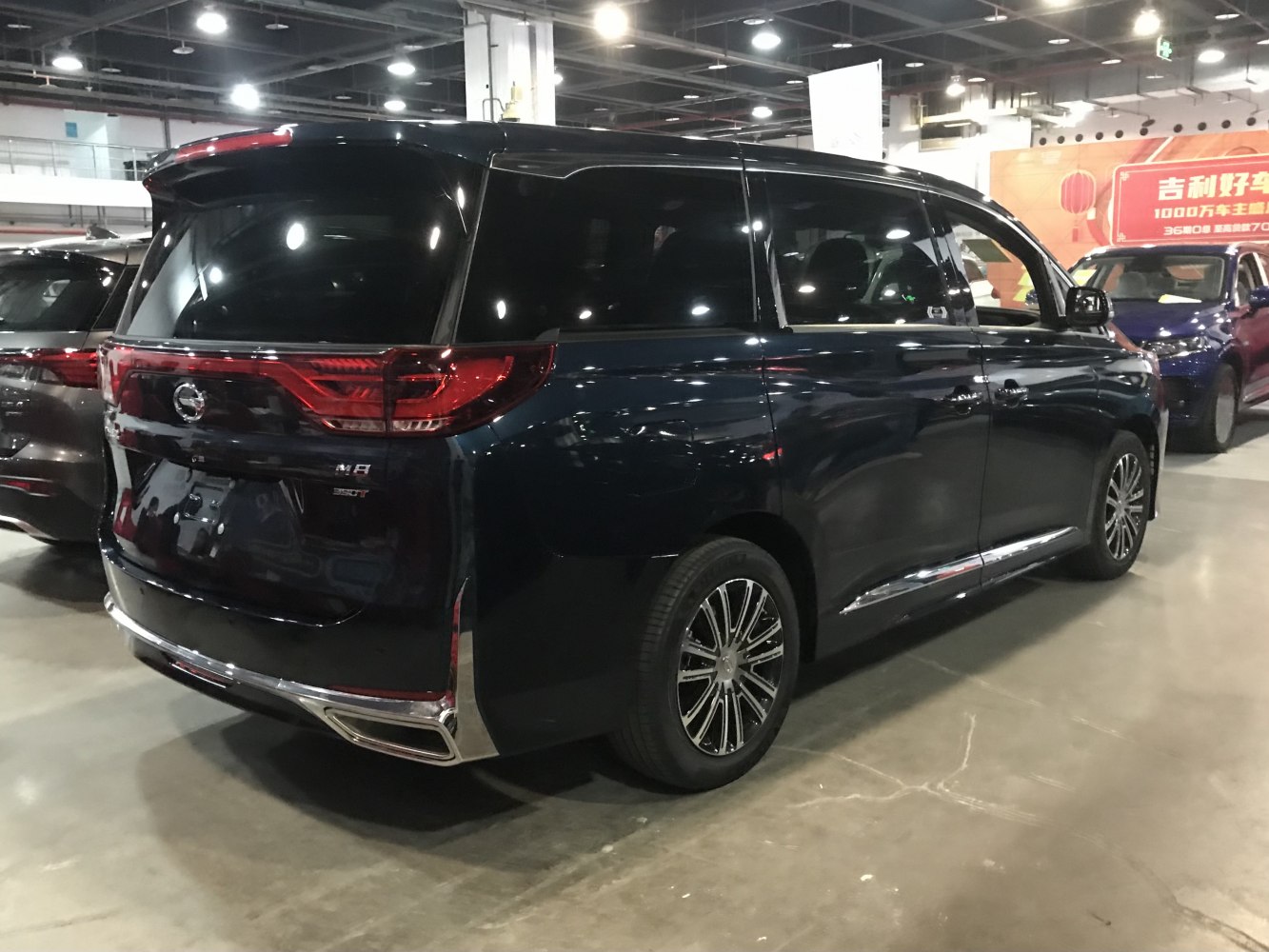 Rear and side view of a minivan with multi-spoke wheels and tinted windows