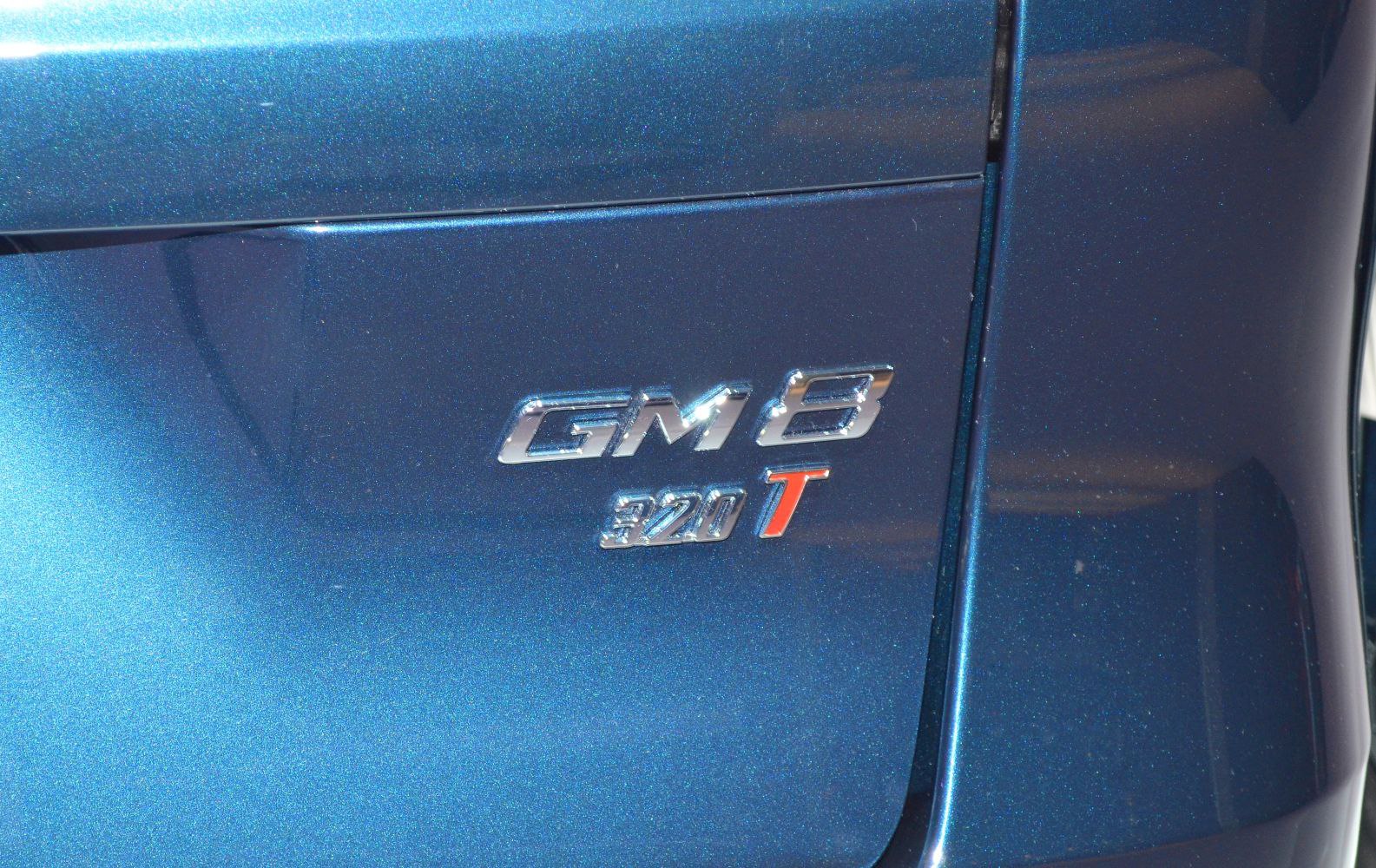 Chrome GM8 320T badge on blue vehicle panel