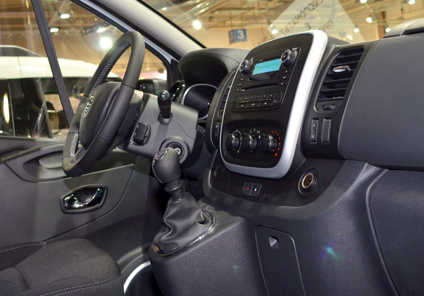 Van interior featuring steering wheel, dashboard, manual gear shift