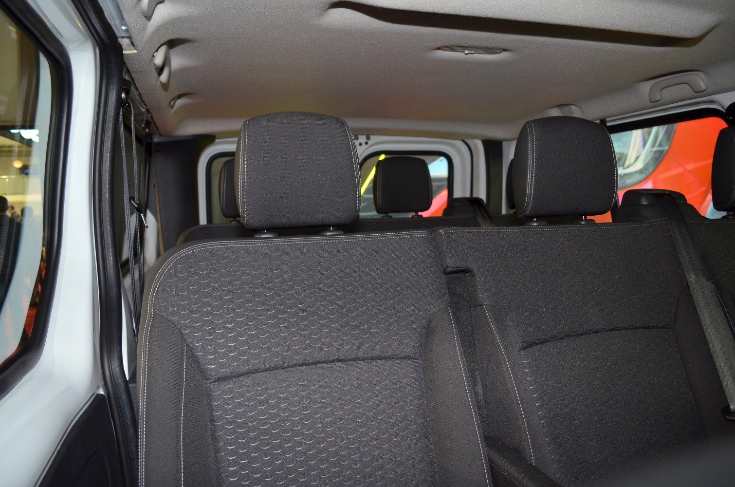 Rear passenger seats and headrests with textured fabric upholstery inside a van