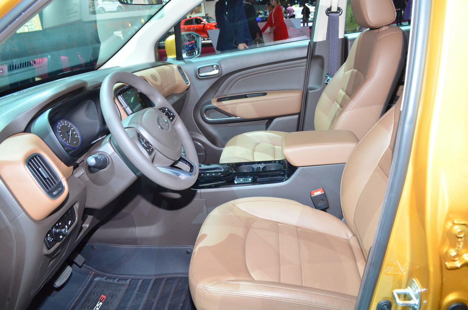 Tan leather front seats and modern dashboard with steering wheel and center console